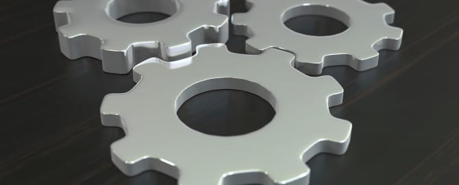 Business composition with metal gears on dark wooden tabletop